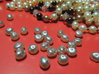 pearls on a red background.scattering of beads and beads.