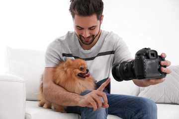 Professional animal photographer taking picture of beautiful Pomeranian spitz dog at home