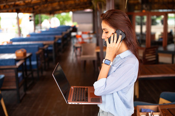 Portrait of female restaurant manager. Businesswoman work with laptop and mobile phone in cafe. - 311235276