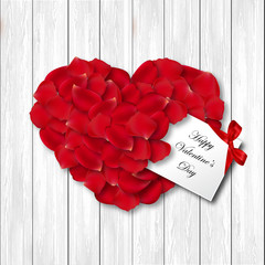 Valentine's day card. Red rose petals heart shape on wood board.