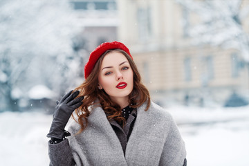 Outdoor close up portrait of young beautiful elegant woman with red lips makeup,  wearing beret,...
