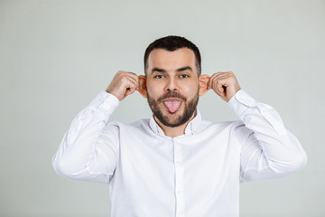 portrait of funny bearded man fooling around on gray background.