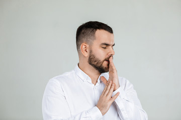 doubtful bearded man thinking about something on gray background.