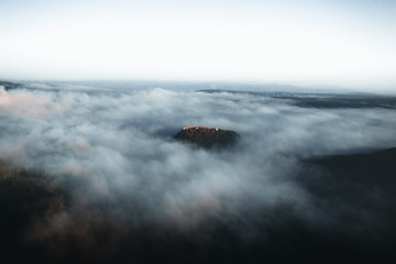 Amazing aerial view of foggy and colorful forest on sunrise. Autumn landscape. Drone shot