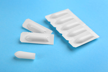 Suppositories on light blue background. Hemorrhoid treatment