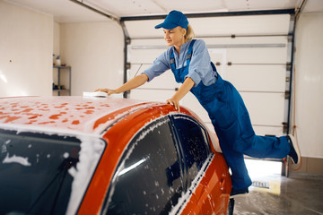 Fototapeta na wymiar Female washer wipes the automobile windshield