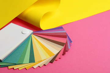 Color palette and yellow paper on pink background
