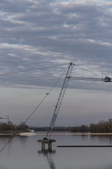 Fototapeta premium Seagull sitting on a rope above the river