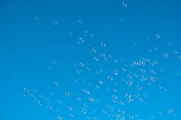 Soap bubbles flying on clear blue sky background, bubble float concept