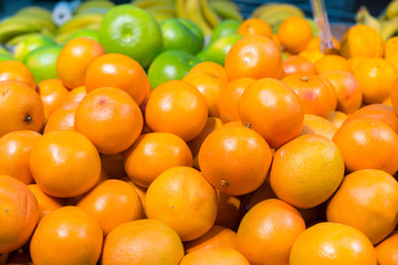 Close up view of madarines orange on the sheft in the supermarket. Healty and fresh fruits background in a supermarket super store. Fresh oranges are on the greengrocer's counter
