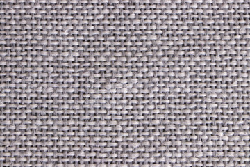 The texture of the weaves of woolen gray fabric. Closeup.