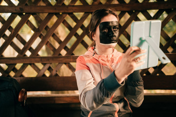 Young make up artist drawing on her face with watercolor.