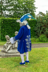 A man standing in mask and masquerade costume in Annevoie  gardens, Belgium - 311239422