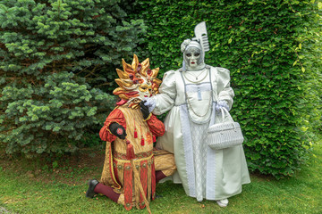 Couple standing in masks and masquerade costumes during Venetian carnival in Annevoie  gardens, Rue des jardins, 37 a, Annevoie/ Belgium - 311239490