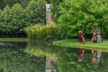 Actors in mask and masquerade costume ia  water gardens of Annevoie, between Namur and Dinant, Belgium - 311239833
