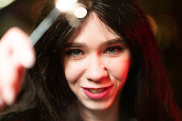 Fototapeta premium beautiful girl with sparklers in the evening on the street. festive mood sparkling hand-held fireworks.