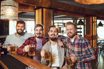 A group of people watching tv football in a sports bar.
