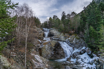 Sant Esperit waterfall in National Park of Aigüestortes and lake of Sant Maurici.