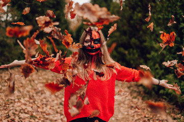 Young blonde girl with halloween face art posing outdoor.  Helloween celebration concept.