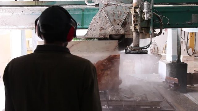 workers near industrial marble saw machine cutting 
