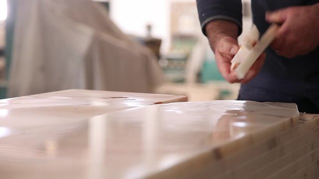 man with a hammer breaking  excess from block of marble stone , slider shot