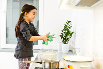 Little cute girl is cooking on kitchen. Having fun while making cakes and cookies