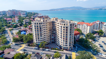 Multi-storey residential buildings on the shore of Gelendzhik Bay. Aerial view. Visible sea, mountains, beach. 