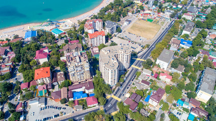 Multi-storey residential buildings on the shore of Gelendzhik Bay. Aerial view. Visible sea, mountains, beach. 