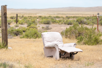 Comfy abandoned easy chair rotting in the desert in Mandalay Spring Nevada