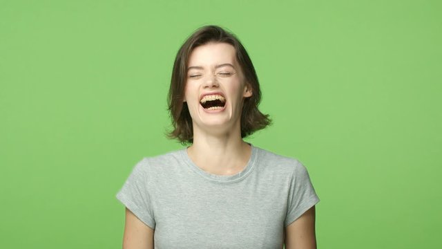 Slow-mo cheerful attractive woman starts laughing, cant stop chuckling, with broad beaming smile, wear cute braces, bend and shaking from giggle, touch chest and pointing camera, hear funny joke
