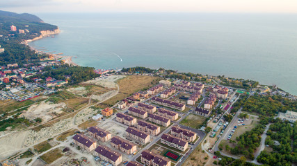 Residential complex of more than twenty five-storey houses on the beach at sunset