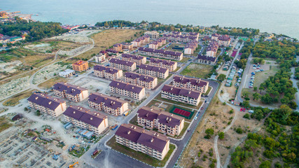 Residential complex of more than twenty five-storey houses on the beach at sunset