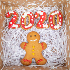 Gingerbread man with 2020 on white textured background in box, flat lay, Christmas and  new year concept,  top view,  copy  space 