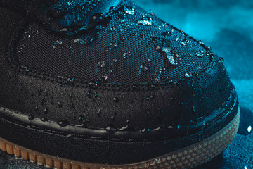 Water drops on waterproof membrane fabric of shoes surface, macro shot. New waterproofing...