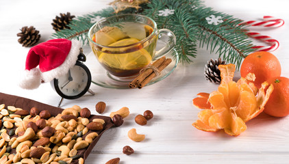 tea nuts and Christmas tree branches on a white wooden background