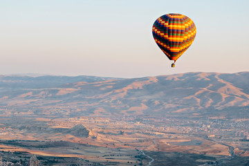 Aerial view of hot air balloons flying over Turkish mountain landscape in the Goreme National Park, Cappadocia