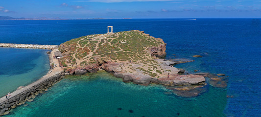 Aerial drone ultra wide photo of iconic ancient temple of Apollo or Portara located in main port and town of Naxos island, Cyclades, Greece