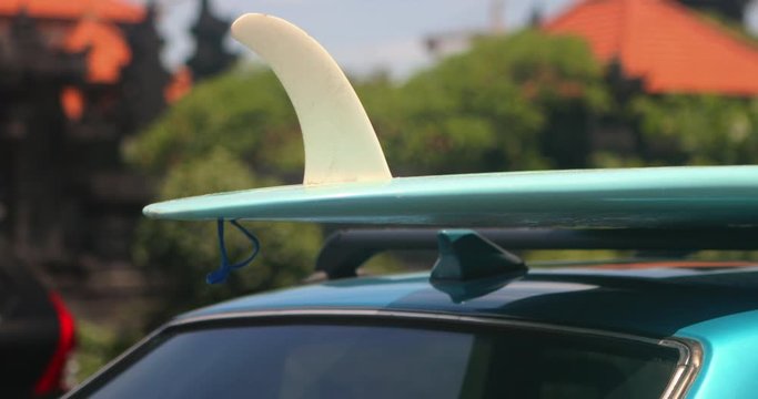 Blue vintage classic car with turquoise long board surfboard and white single fin. Idyllic surfing way of life at the ocean. Summer vacation concept. Modern hipster vacation. Extreme sport.