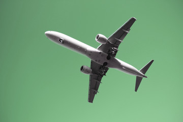 Fototapeta na wymiar Flugzeug in der Luft mit ausgefahrenem Fahrwerk im Landeanflug und monochromer Hintergrund - Stockfoto
