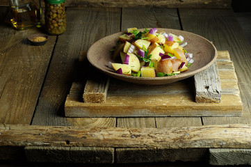 Boiled potato salad with Dijon mustard, spices, red onions and herbs. Capers, olive oil on wooden background. Vinaigrette. Horizontal arrangement