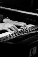 Fototapeta premium hands on the keys of a synthesizer to play the melody.black and white photo.
