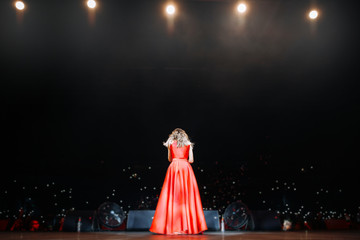 Silhouette of singer at the long dress on stage