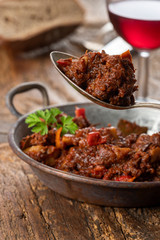 portion of austrian goulash on wood