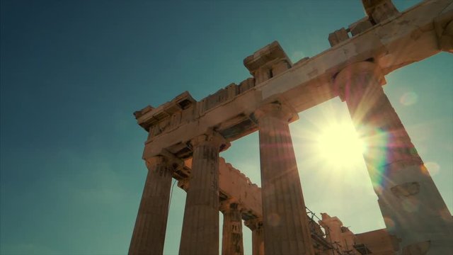 Sun shines between the columns of the Parthenon at the Acropolis in Athens, Greece