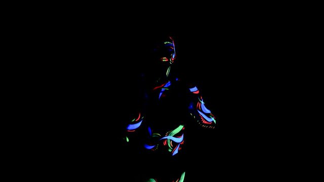 Fantastic dancer with glow in the dark bodypaint circling her arms around her.