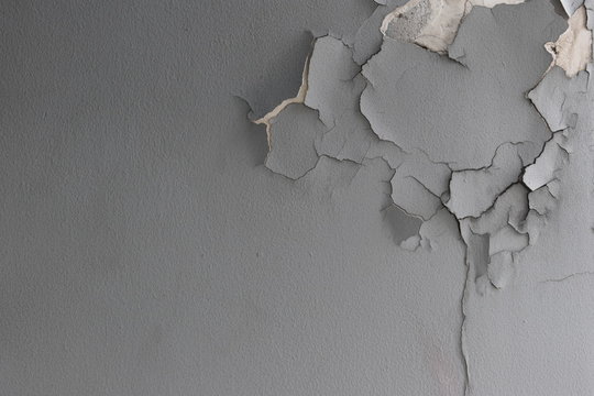Background texture of old cement wall with gray paint peeling off.