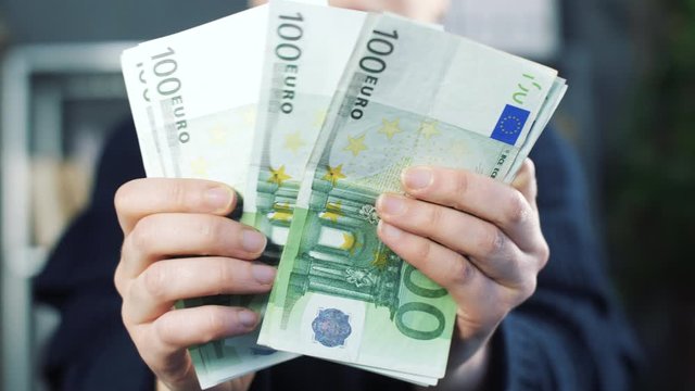 Close up of counting money. Nominal of 100 euro notes counting. Business bills money. Tax day or getting a paycheck for work. 4k slow motion footage.