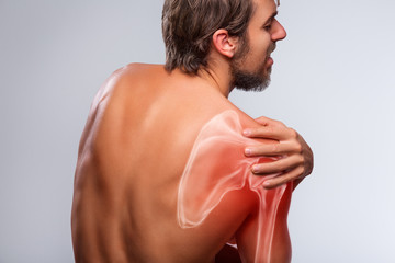 Shoulder pain. Man holding a hand on shoulder