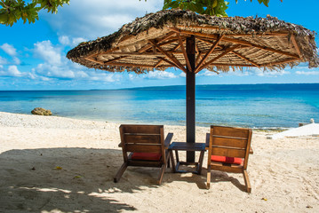 Two deck chairs on a sandy beach in Vanuatu.