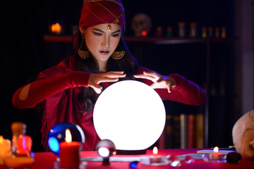 Fortune-teller woman is predicting with a shining crystal ball